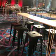 A room with White hairpin High Bar Tables and stools in it.