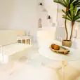 White round coffee table being hired next to a white lounge