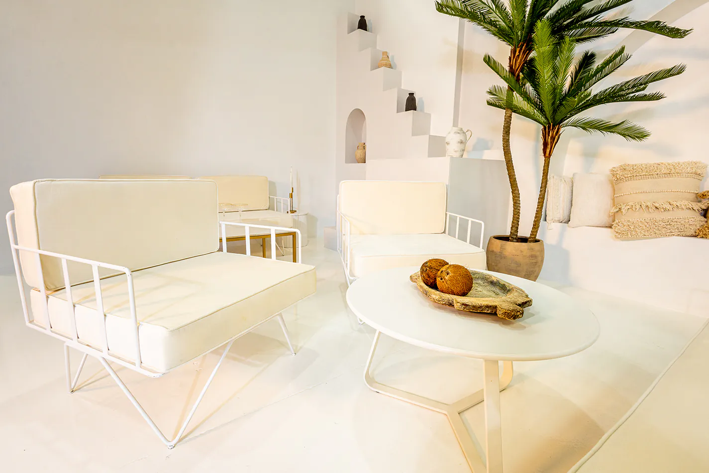 White round coffee table being hired next to a white lounge