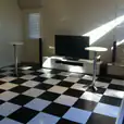 Our white top bar table in a living room with a black and white checkered floor.