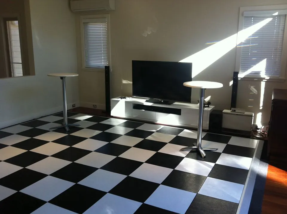 Our white top bar table in a living room with a black and white checkered floor.