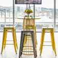 A yellow wire cocked table table inside of a bar area
