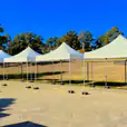 A row of 3mx3m pop-up marquees with white roofs in a parking lot.