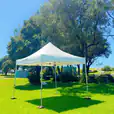 A 3mx3m white tent set up in a grassy field.
