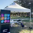 A 3mx3m pop-up marquee with a white roof set up in a grassy area.