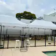 A 3mx6m pop-up marquee with a white roof stands next to a swimming pool.
