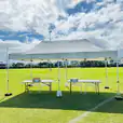 A 3mx6m pop-up marquee with a white roof set up on a grassy field.