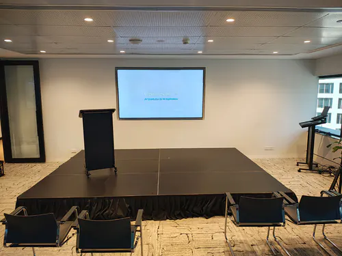 A black stage set up with a lectern for an event