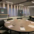 A large round office table with two partitions in the background