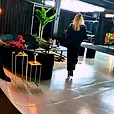 Black velvet ottoman stools used as loose seating in an industrial event space with black draping.