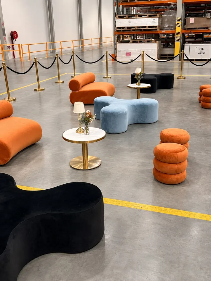 Black and sky blue Apollo daybeds with Sienna ottomans, gold bollards and an Atlas coffee table at an event