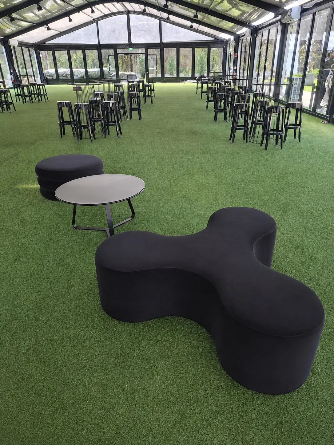 Apollo tripod day bed in black velvet styled with ottomans at an event