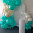 A balloon garland with aqua and white balloons