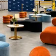 Black Apollo daybed and ottomans with a brass cocktail table in a styled event lounge
