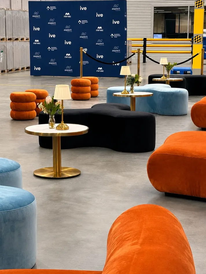 Black Apollo daybed and ottomans with a brass cocktail table in a styled event lounge