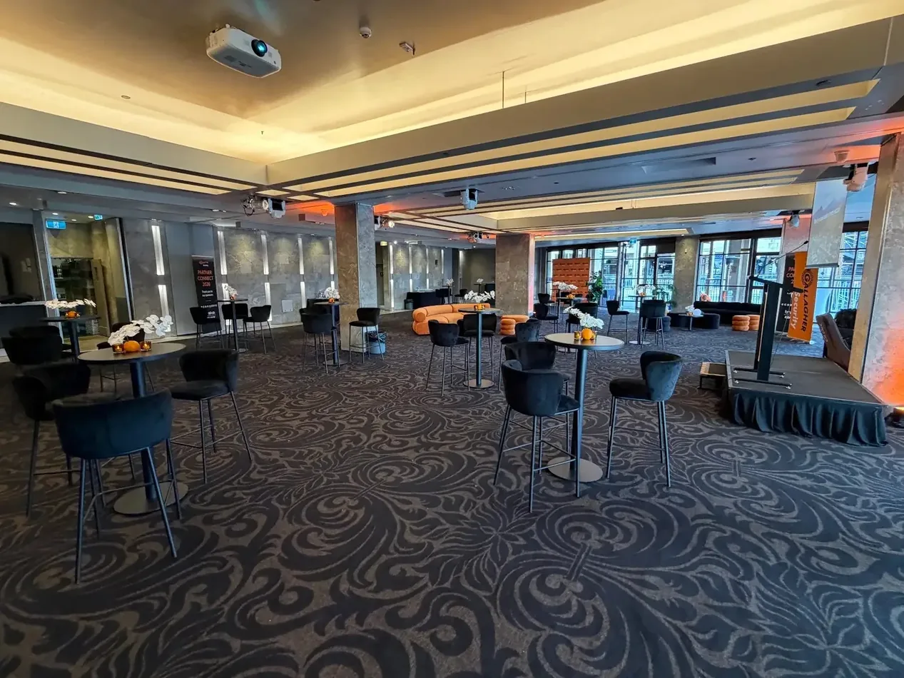 Black Atlas bar tables with black velvet bar stools at an indoor event