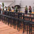 Multiple black bentwood bar stools arranged at a high bar table for a corporate cocktail function