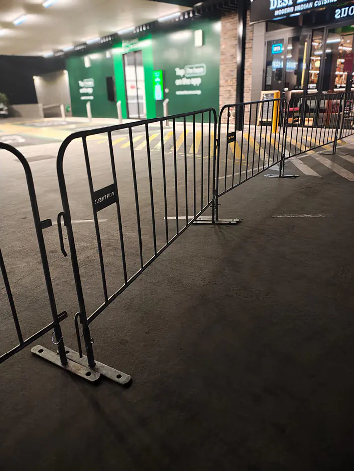 Black crowd control barriers installed outside a venue entrance for organised event access and pedestrian management