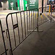 Black crowd control barriers installed outside a venue entrance for organised event access and pedestrian management