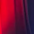 Black event draping with red uplighting behind a lounge and cocktail seating area in an indoor event venue