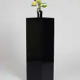 A large black vase stands on top of a square plinth.