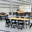 A large warehouse with black padded folding chairs set up.