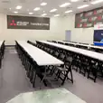 A large room with black padded folding chairs set up on tables.