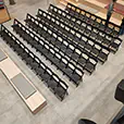 Rows of black padded folding chairs arranged theatre-style for a conference or presentation event in a modern venue