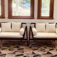 Two black rattan lounge chairs in front of a window.