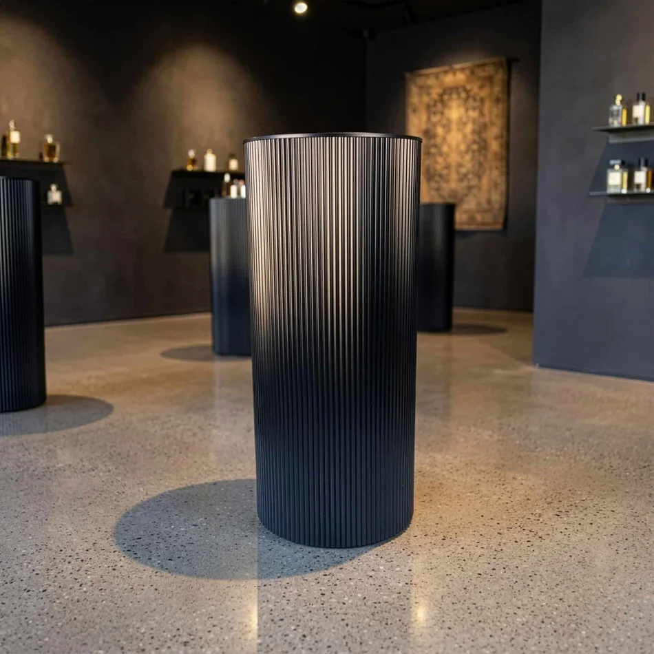 Black ripple metal plinth used as a display pedestal in an interior setting