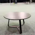 A black round coffee table in a large conference room.