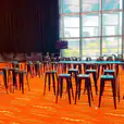 A spacious room filled with numerous tables and chairs, available for Black Tolix Stool hire.