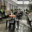A cafe with tables and chairs, including black Tolix stool hire, in an office building.