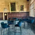 Black velvet bar stools arranged around a black Atlas bar table at an indoor event