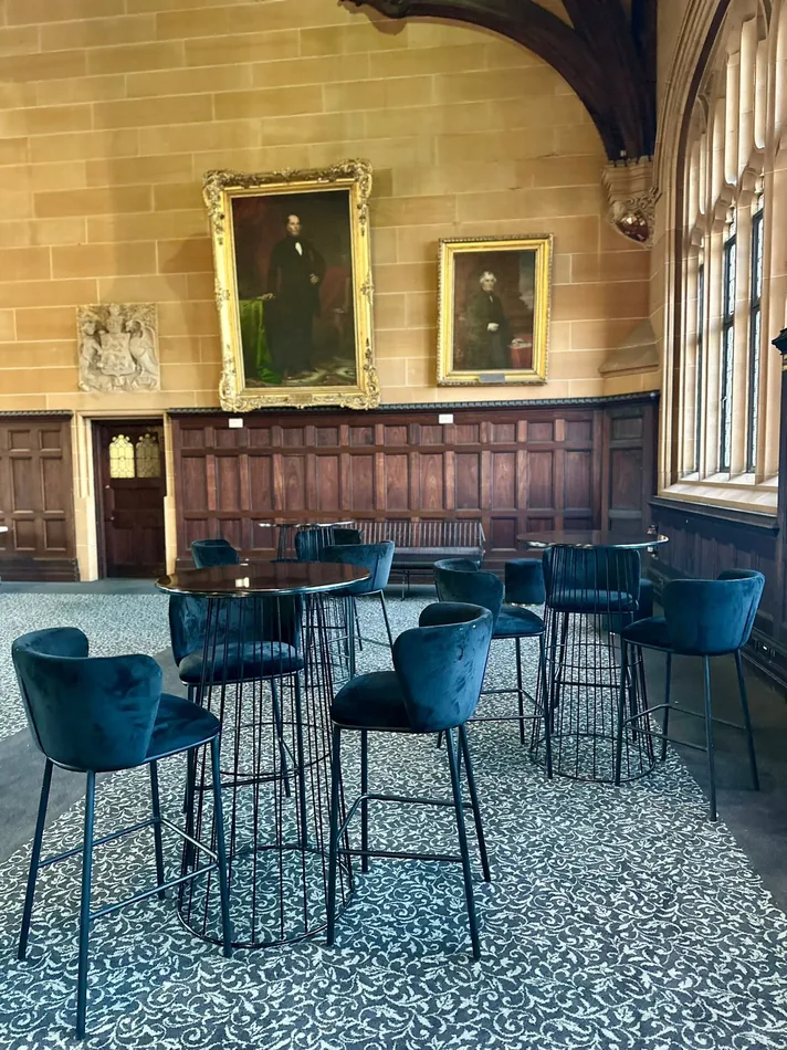 Black velvet bar stools arranged around a black Atlas bar table at an indoor event