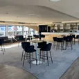 Black velvet bar stools surrounding a cocktail table at a modern event venue