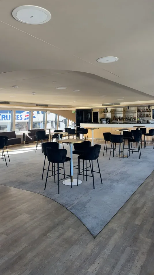 Black velvet bar stools surrounding a cocktail table at a modern event venue