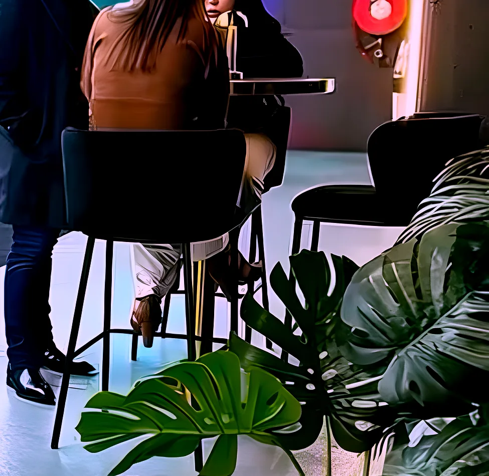 Brass cocktail bar table in use with black velvet bar stools at a supercar showroom event.