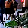 Brass cocktail bar table in use with black velvet bar stools at a supercar showroom event.