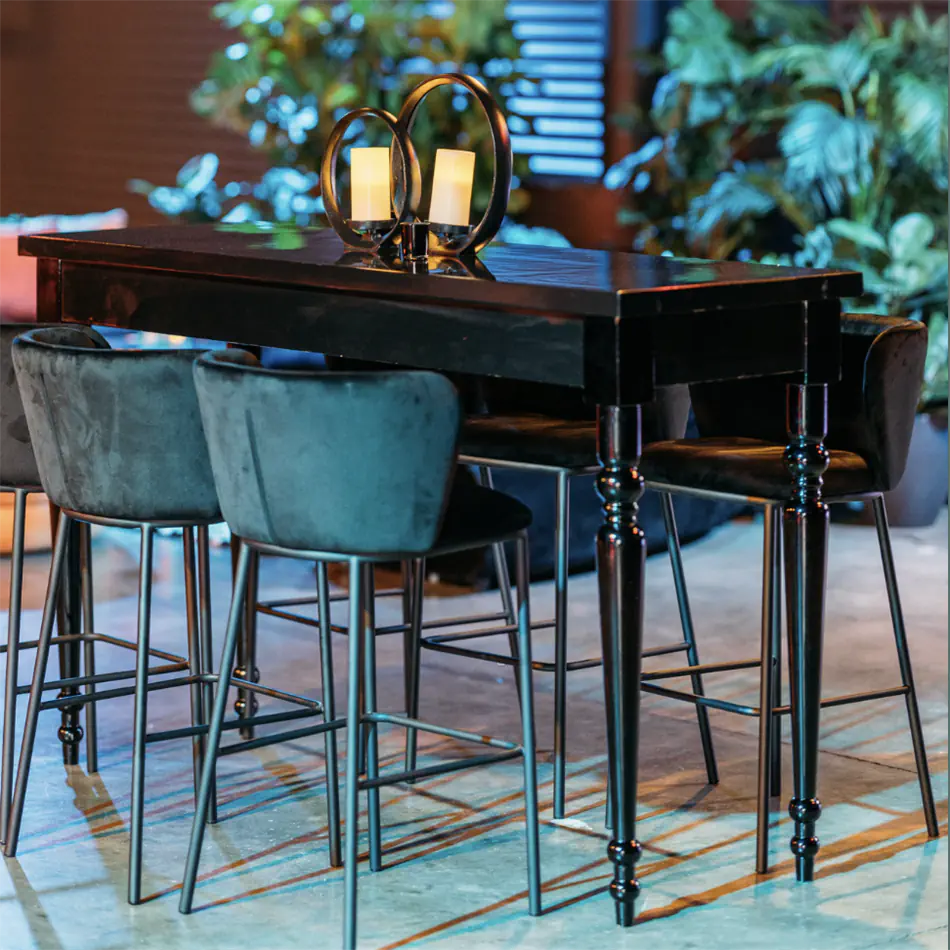 Black velvet bar stools arranged at a high bar at a corporate cocktail event