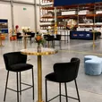 Black velvet bar stools around a brass cocktail table with blue marble top