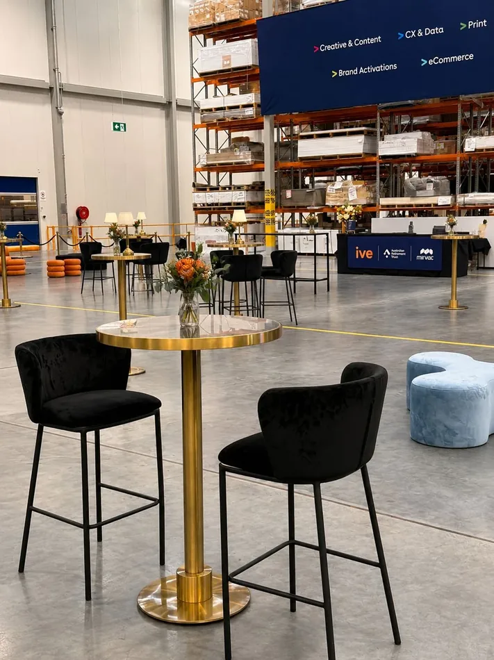 Black velvet bar stools around a brass cocktail table with blue marble top