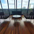 Black velvet wire lounge chairs with matching sofa and round coffee table positioned beside floor-to-ceiling windows in a modern venue