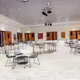 A spacious room with tables and chairs in it, where you can hire black wire coffee tables.