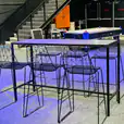 A bar table with four stools, including black wire stools for hire, and a basketball hoop.