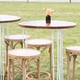 Blonde bentwood bar stools paired with timber tables at a garden wedding event
