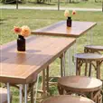 Multiple blonde bentwood bar stools at an outdoor cocktail party with natural timber furniture