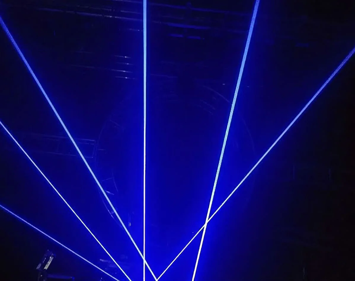 Hire a blue laser light on a stage in a dark room for an immersive experience.