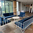 Blue velvet wire lounge seating with matching armchairs and white round coffee table arranged inside a modern function venue