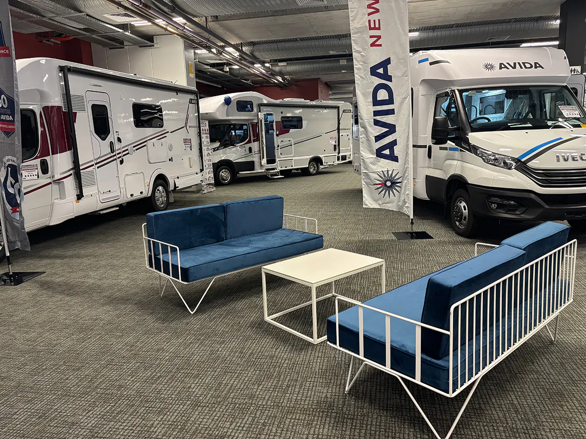 A blue wire 2 seater sofa at a campervan show